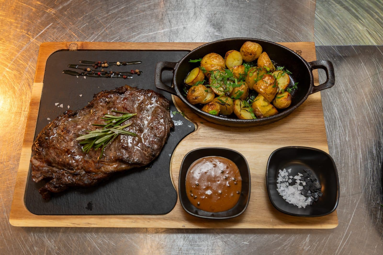 Ribeye servit pe blat de lemn cu garnituri